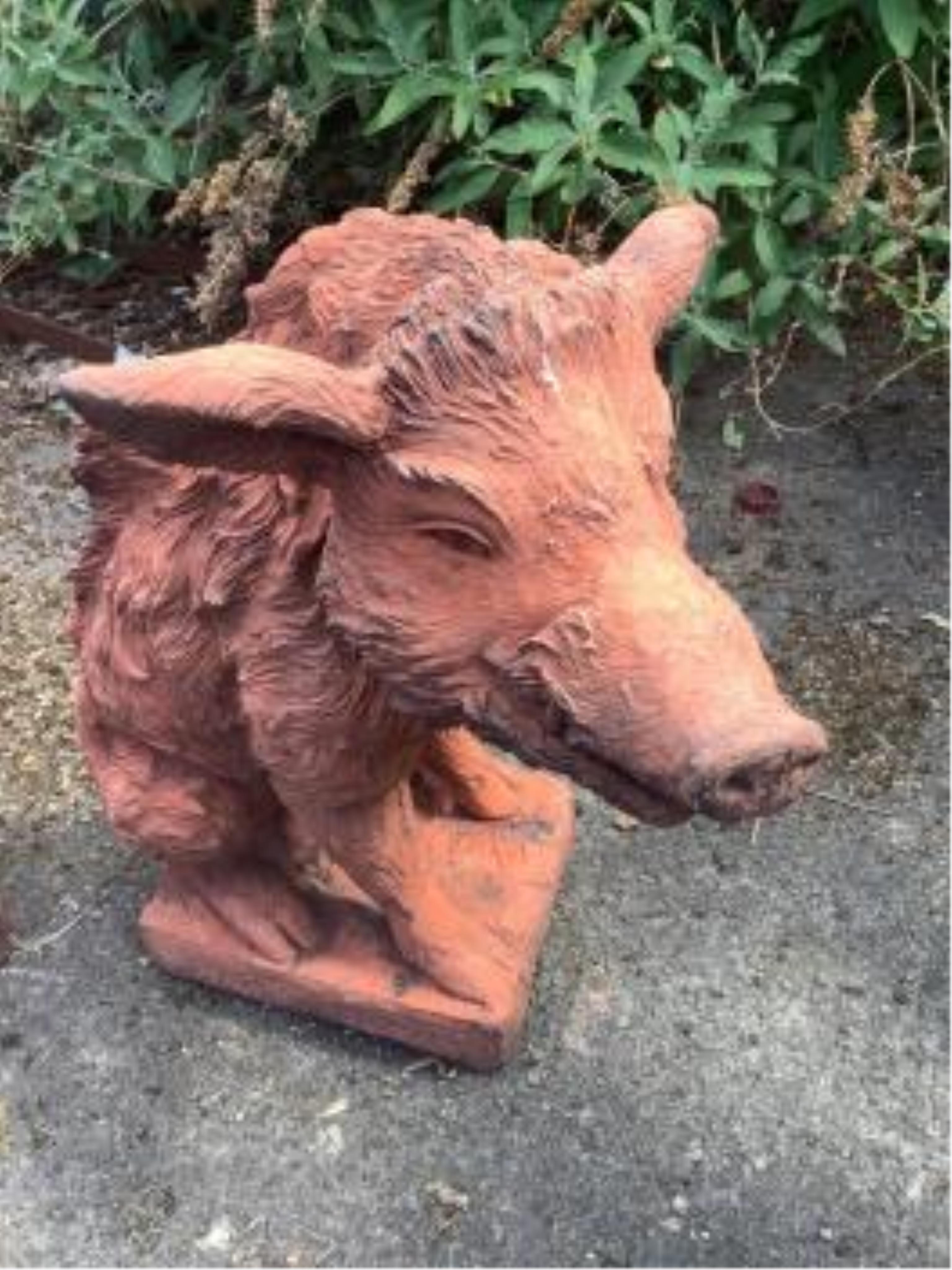 A pair of terracotta seated wild boar garden ornaments